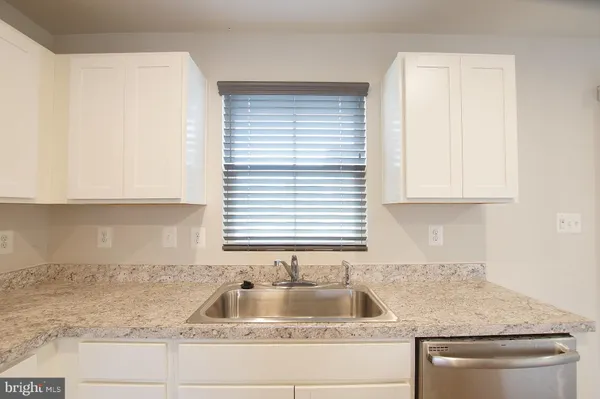a kitchen with granite countertop a sink and a window