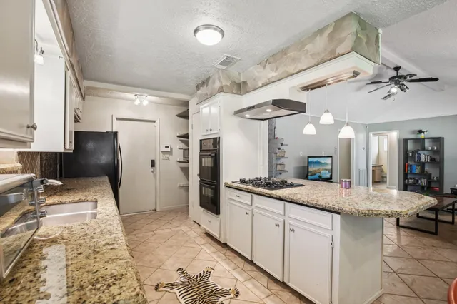 a spacious bathroom with a granite countertop sink a mirror and shower