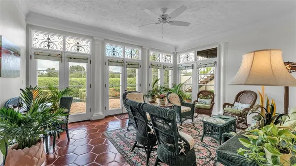 a living room with furniture a chandelier and a floor to ceiling window