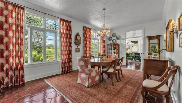 a dining room with furniture a chandelier and wooden floor