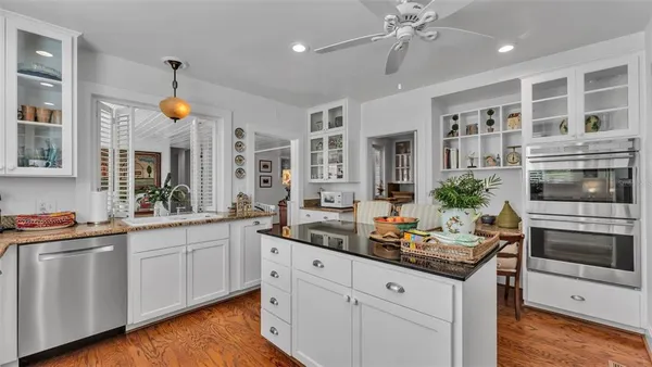 a kitchen with white cabinets and chandelier