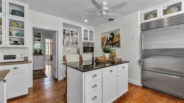 a kitchen with a refrigerator and white cabinets