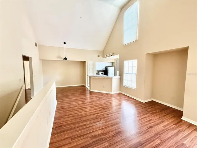 a view of a kitchen with wooden floor and a refrigerator
