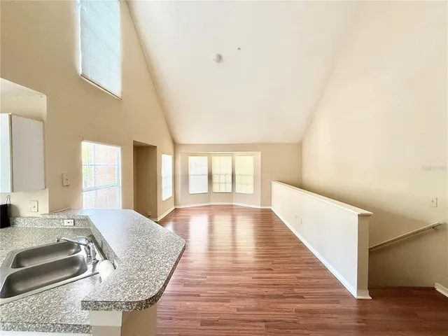 a view of a kitchen with wooden floor and a window