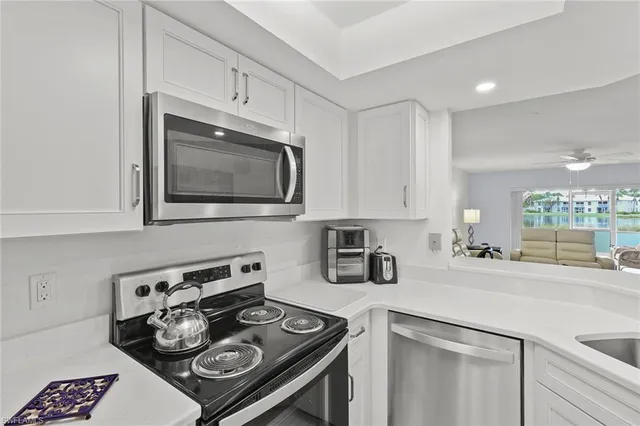 a kitchen with stainless steel appliances a stove a sink cabinets and a microwave
