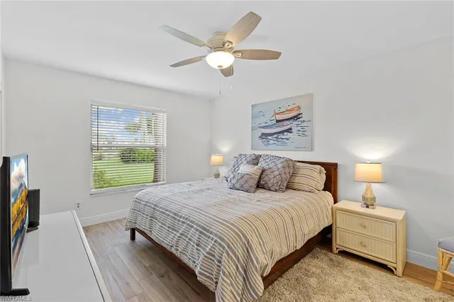 a bedroom with a large bed a chandelier and a window
