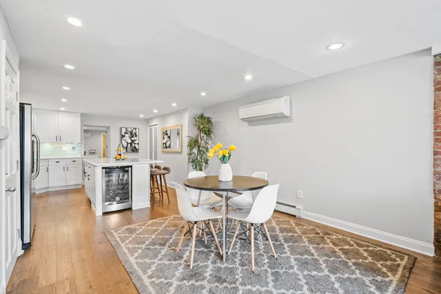 a living room with furniture and a dining table with wooden floor