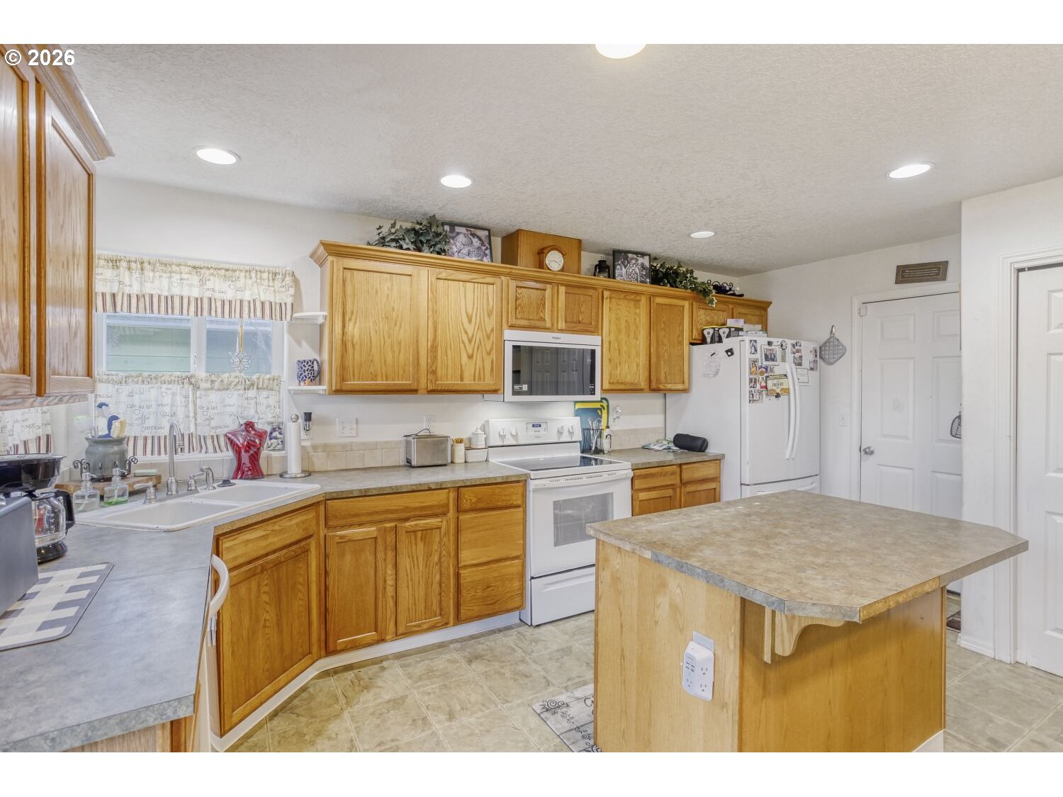 147 Southwest Wright Avenue Troutdale, OR 97060 - Photo 9 of 27 a kitchen with a sink refrigerator and cabinets