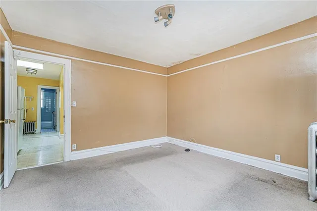 a view of a small space with wooden floor and a window