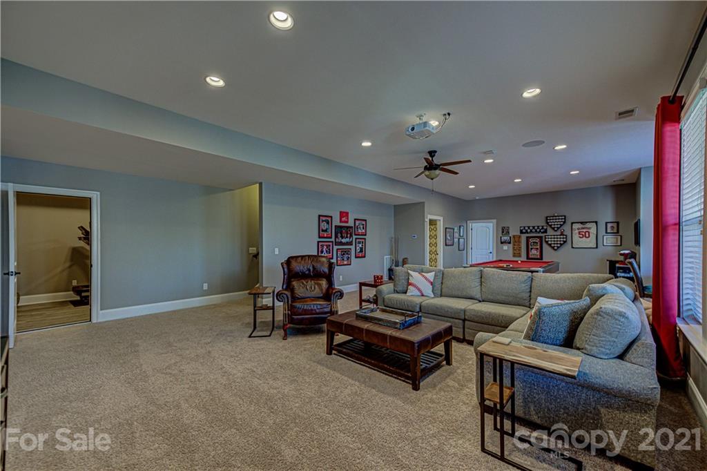133 Forsythia Lane Tega Cay, SC 29708 - Photo 36 of 48 a living room with furniture and a gym with wooden floor