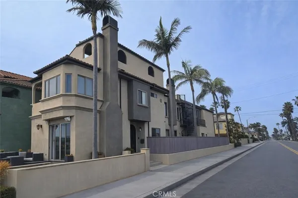 a front view of a house with a palm tree