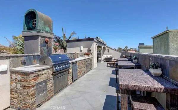 a view of a roof deck with table and chairs a barbeque