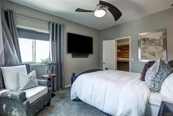 a spacious bedroom with a bed and a television