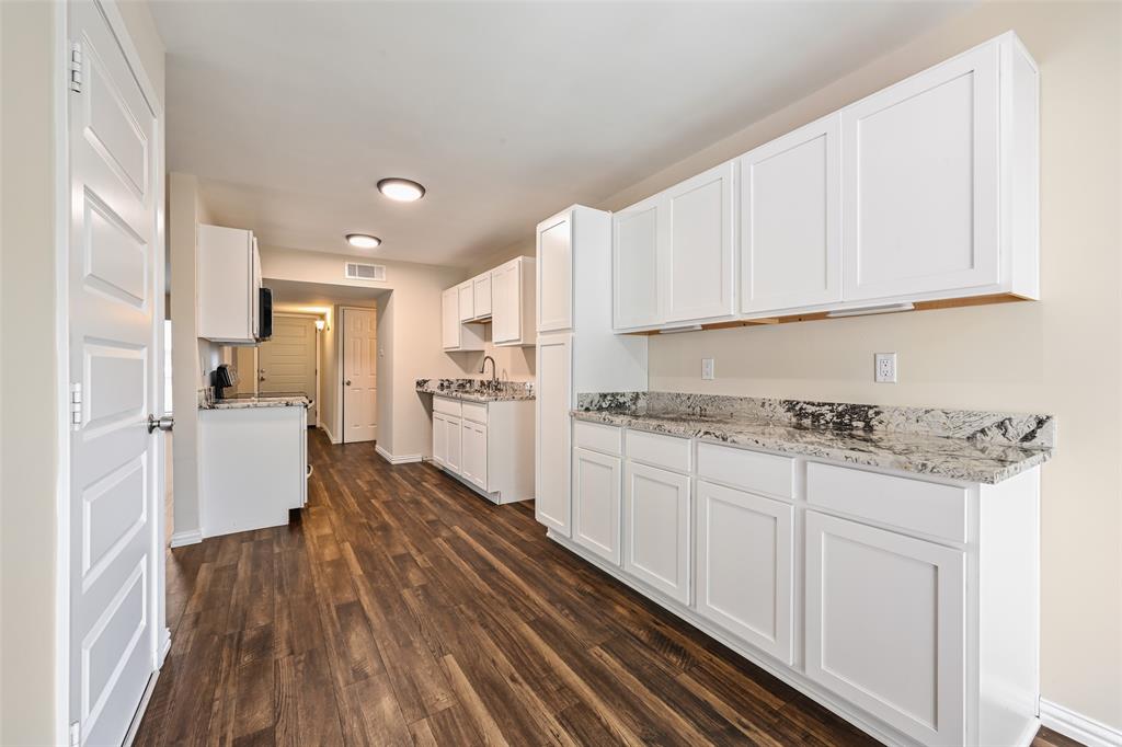 7318 Emory Oak Lane Dallas, TX 75249 - Photo 12 of 28 Kitchen featuring wood-finish flooring, white shaker-style cabinetry, and speckled countertops