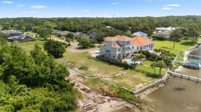an aerial view of residential houses with outdoor space and river