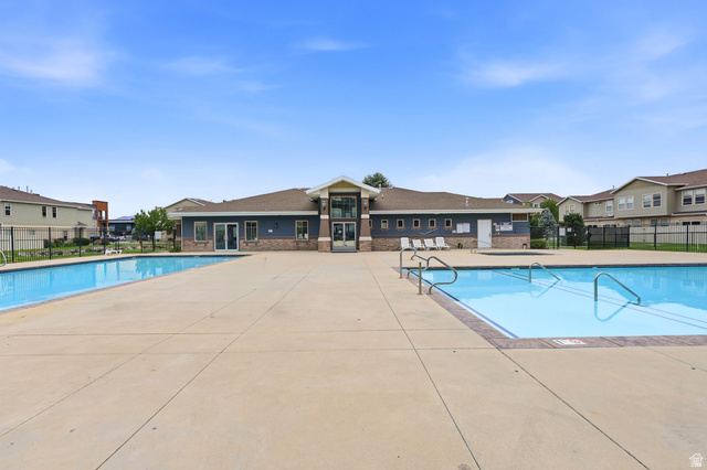 116 East Resaca Drive, Unit F6 Sandy, UT 84070 - Photo 32 of 32 Community clubhouse featuring a brick and siding exterior, multiple swimming pools, and extensive concrete decking