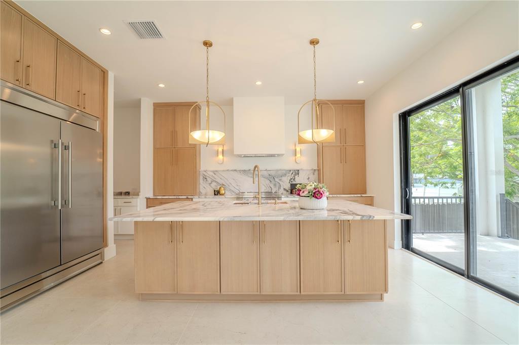 4502 South Shamrock Road Tampa, FL 33611 - Photo 11 of 41 a view of a kitchen with kitchen island a counter top space stainless steel appliances and a large window