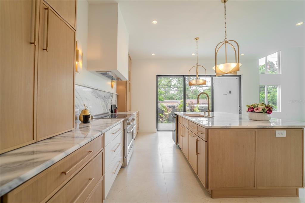 4502 South Shamrock Road Tampa, FL 33611 - Photo 19 of 41 a large kitchen with kitchen island white cabinets and stainless steel appliances