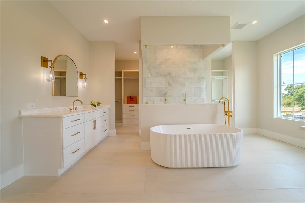 4502 South Shamrock Road Tampa, FL 33611 - Photo 31 of 41 a spacious bathroom with a double vanity sink a mirror and a bathtub