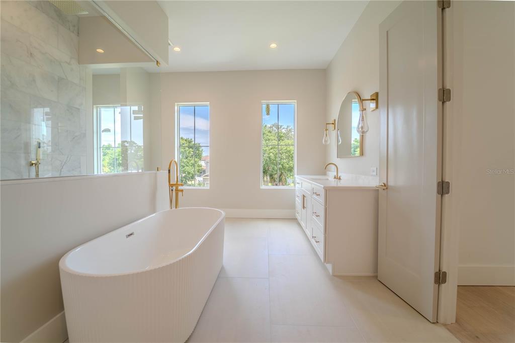 4502 South Shamrock Road Tampa, FL 33611 - Photo 34 of 41 a spacious bathroom with a bathtub sink and mirror