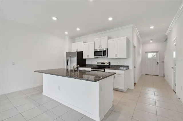 a kitchen with stainless steel appliances granite countertop a sink a stove and a refrigerator