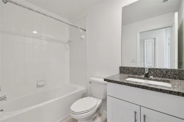 a bathroom with a granite countertop sink and shower