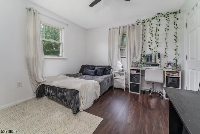a bedroom with a bed window and table chair