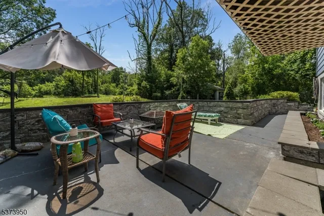 an outdoor sitting area with furniture and umbrella