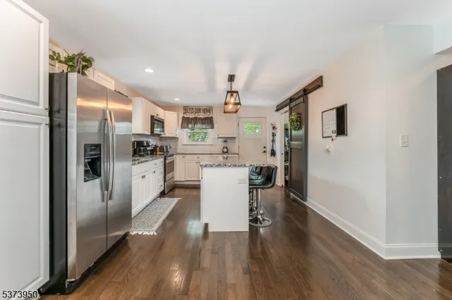 a kitchen with stainless steel appliances a refrigerator and wooden floor
