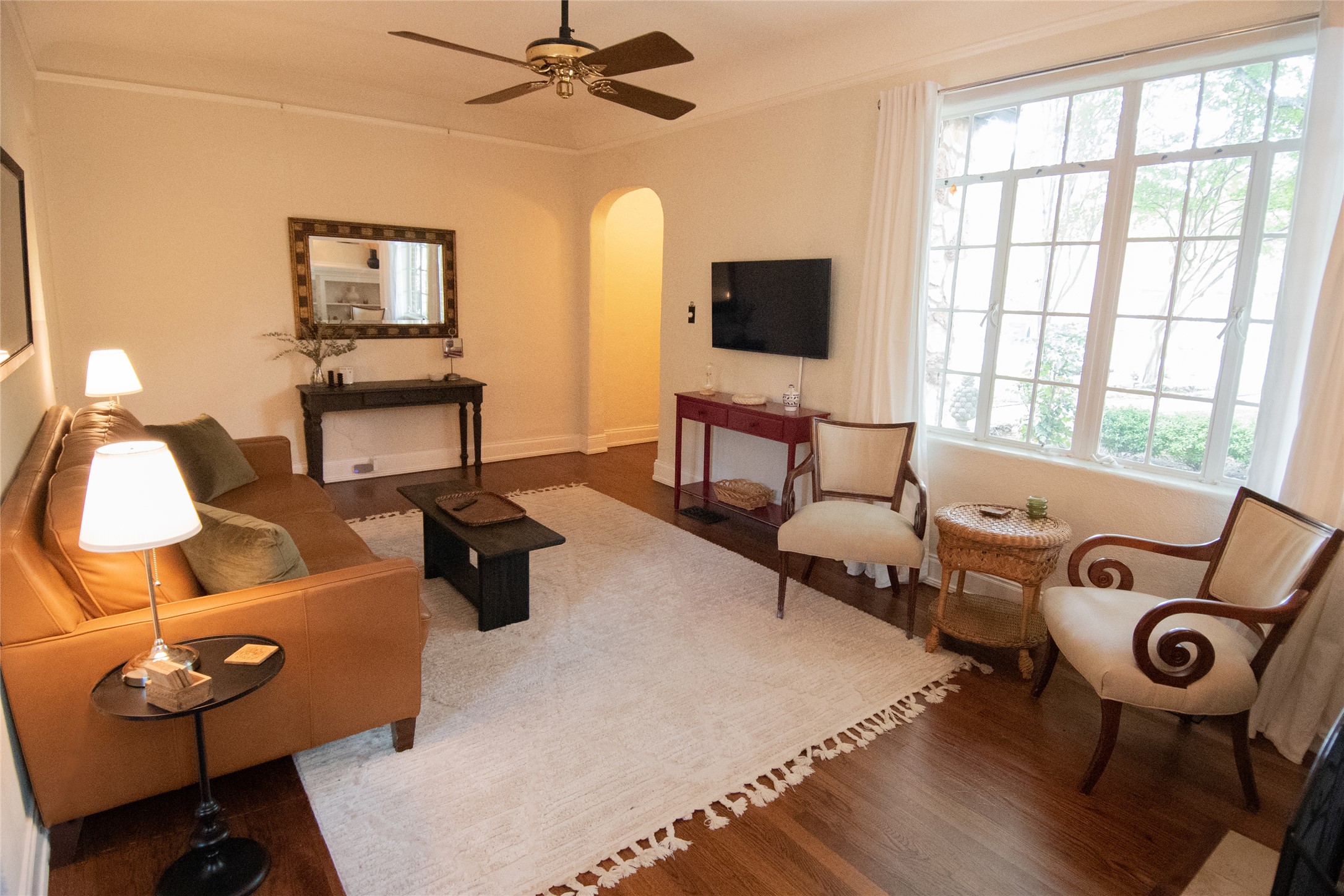 1512 Northwood Road Austin, TX 78703 - Photo 18 of 24 Living room featuring arched walkways, wood finished floors, crown molding, and a ceiling fan
