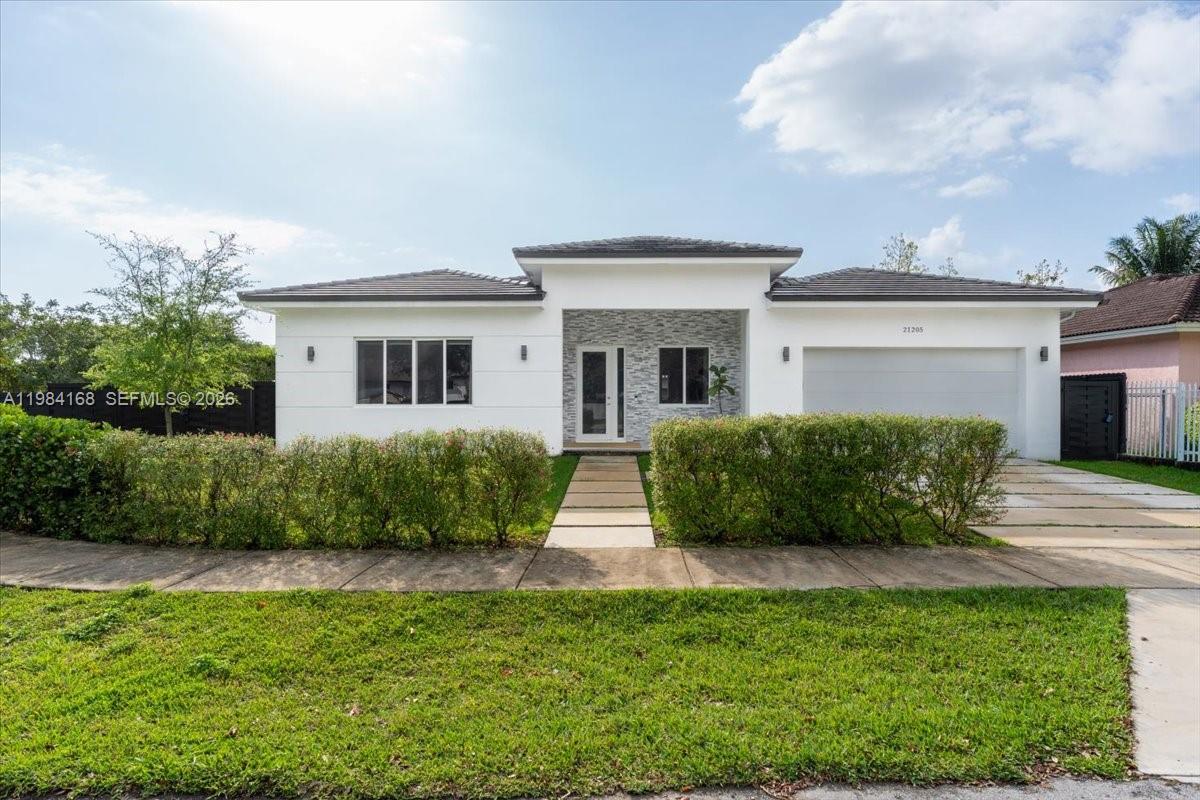 21205 Ingraham Ave Road Cutler Bay, FL 33189 - Photo 2 of 42 a front view of a house with garden
