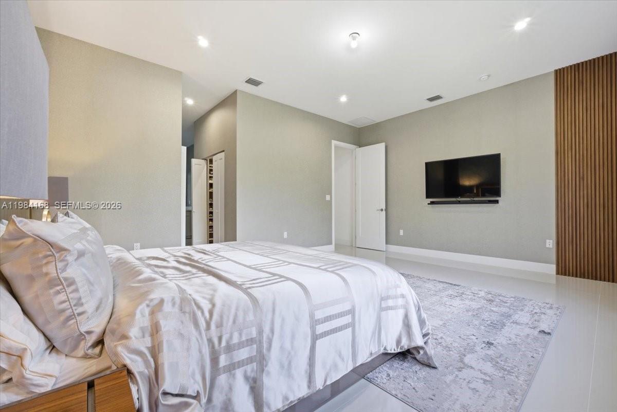 21205 Ingraham Ave Road Cutler Bay, FL 33189 - Photo 24 of 42 a spacious bedroom with a bed and a flat screen tv