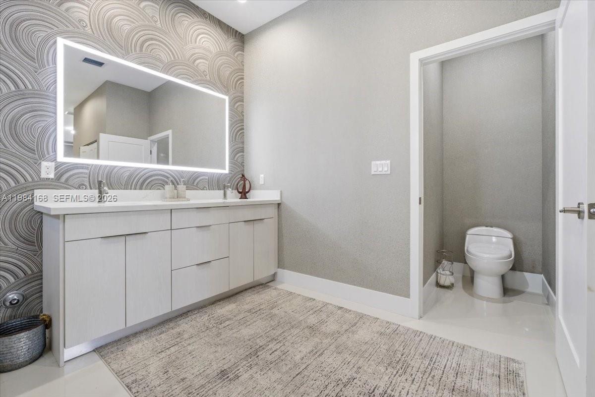 21205 Ingraham Ave Road Cutler Bay, FL 33189 - Photo 28 of 42 a spacious bathroom with a sink a toilet and a mirror