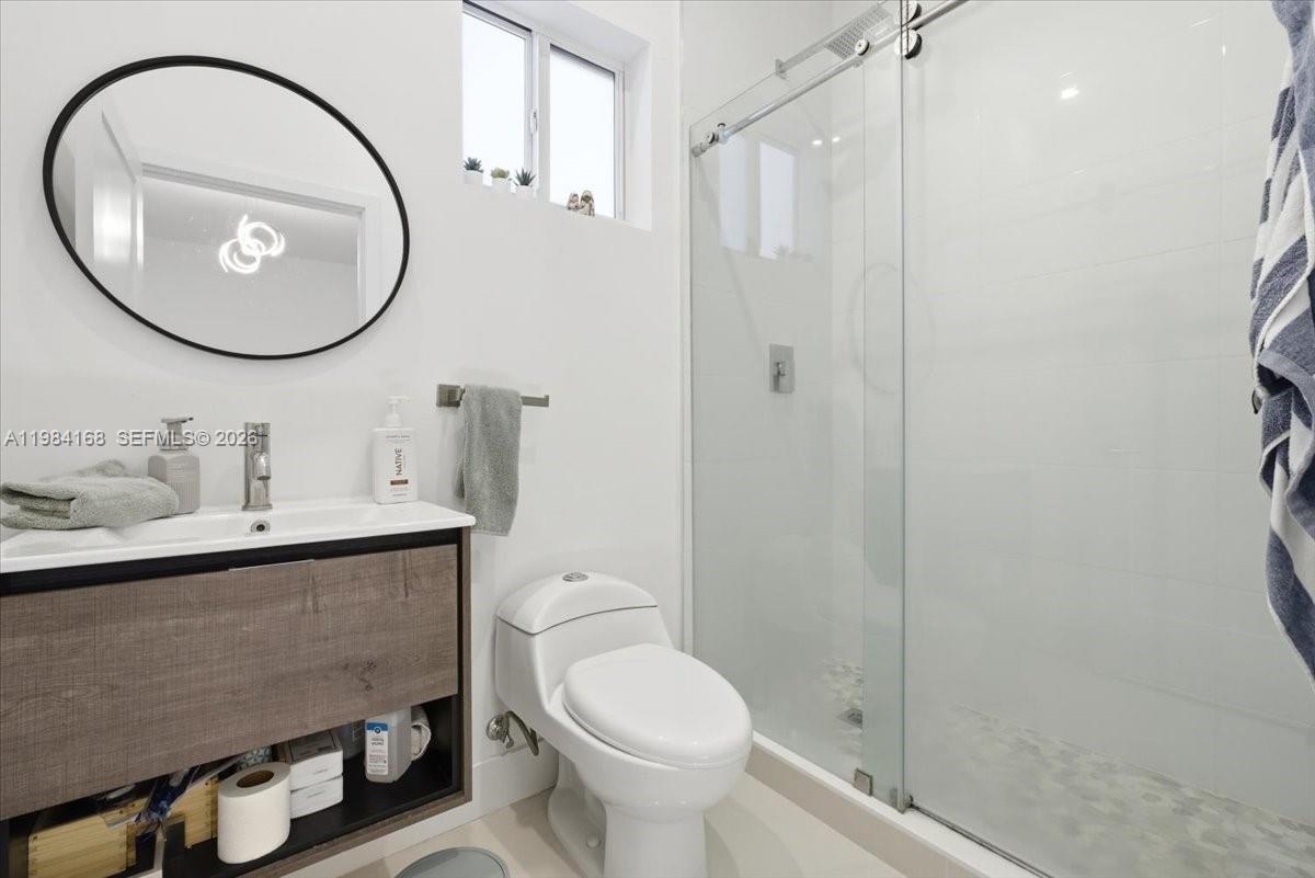 21205 Ingraham Ave Road Cutler Bay, FL 33189 - Photo 33 of 42 a bathroom with a sink a toilet and a mirror
