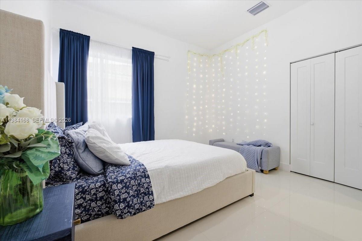 21205 Ingraham Ave Road Cutler Bay, FL 33189 - Photo 35 of 42 a bedroom with a bed potted plant and a window