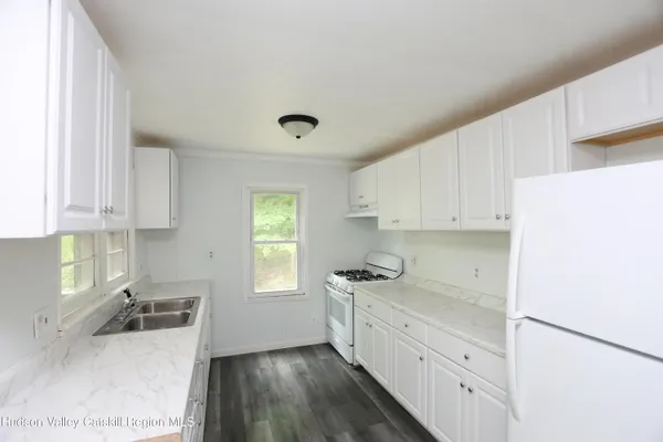 a kitchen with granite countertop white cabinets and white appliances