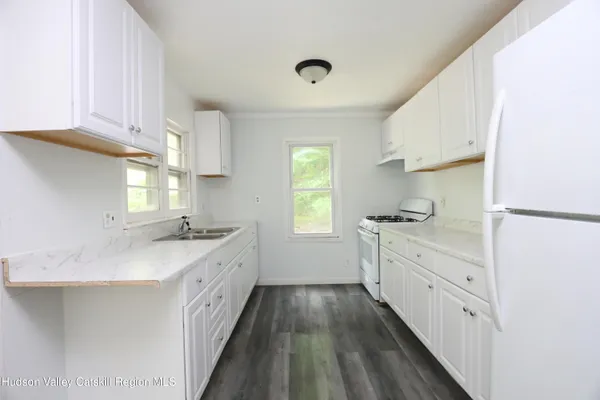 a kitchen with granite countertop a sink and wooden cabinets