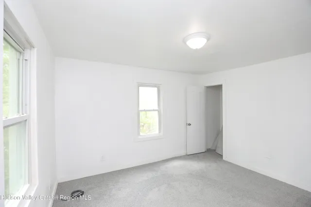 an empty room with windows and closet