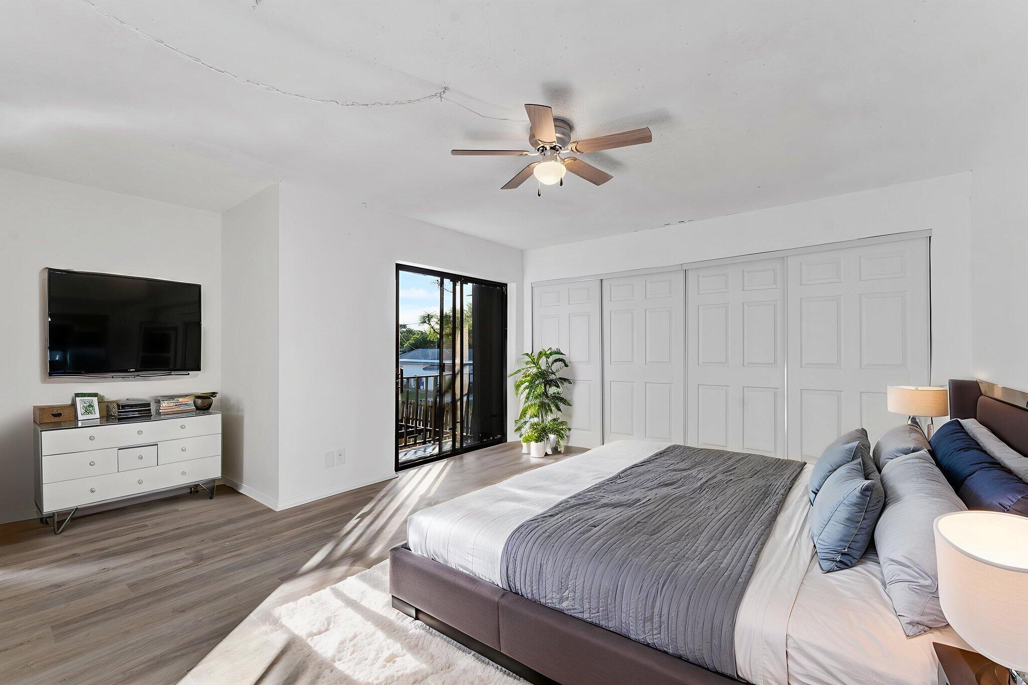 291 Woodland Road Palm Springs, FL 33461 - Photo 25 of 32 a bedroom with a bed and a flat screen tv