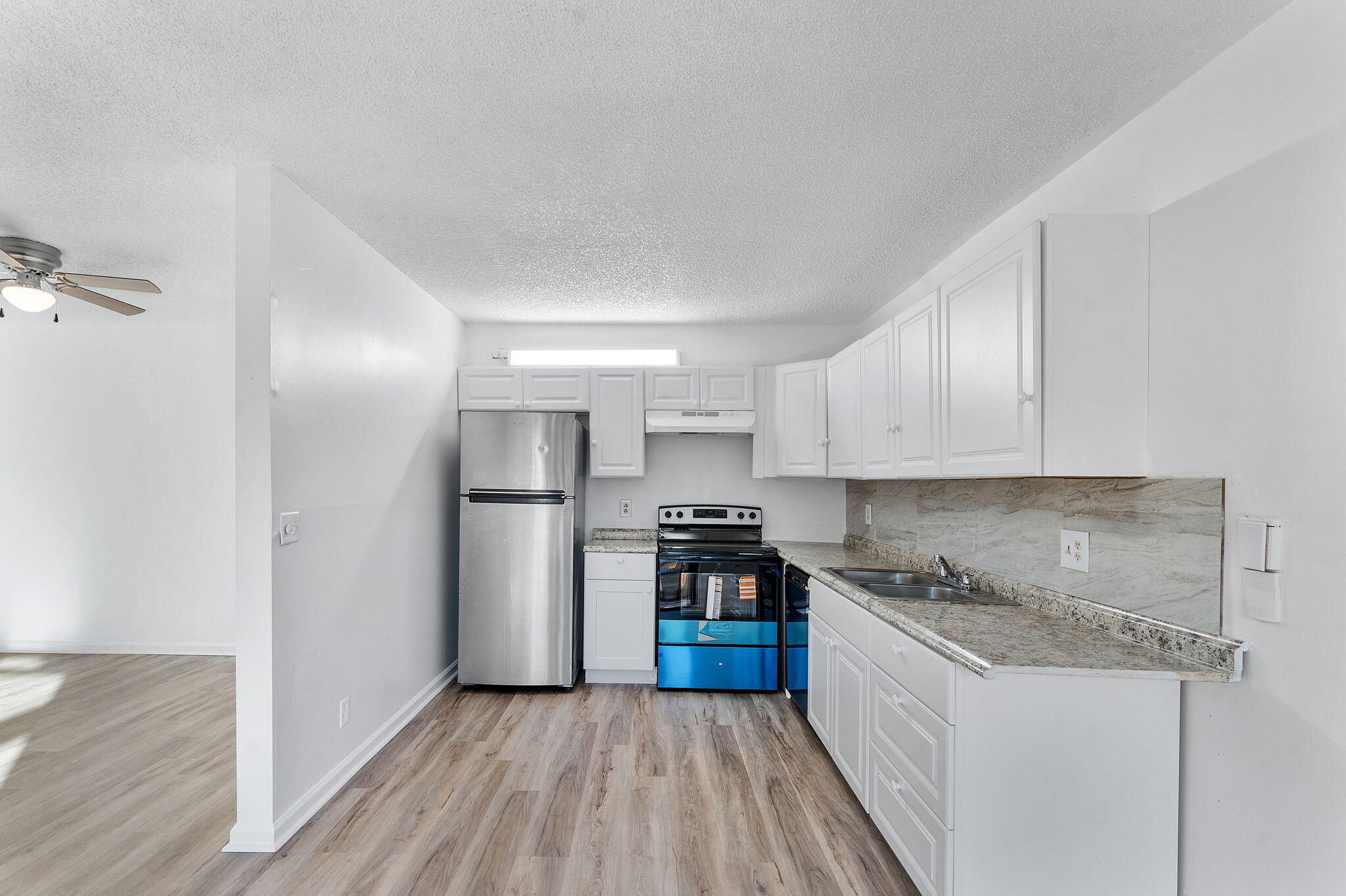 291 Woodland Road Palm Springs, FL 33461 - Photo 7 of 32 a kitchen with stainless steel appliances granite countertop a refrigerator and a stove top oven