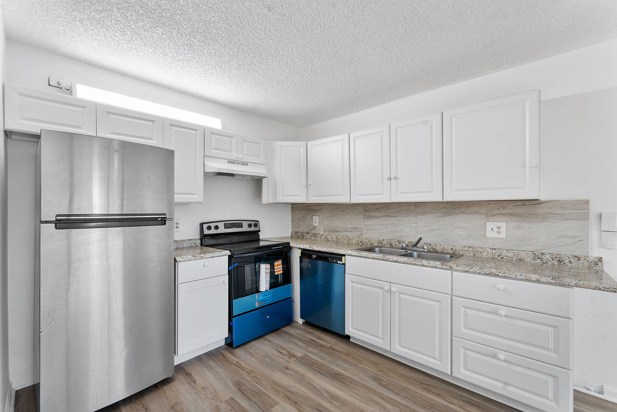 291 Woodland Road Palm Springs, FL 33461 - Photo 8 of 32 a kitchen with a sink stove and refrigerator