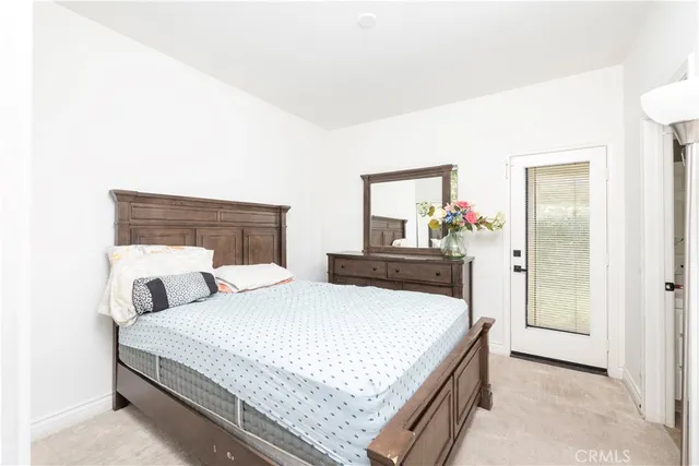 a bedroom with a bed a dresser and a window