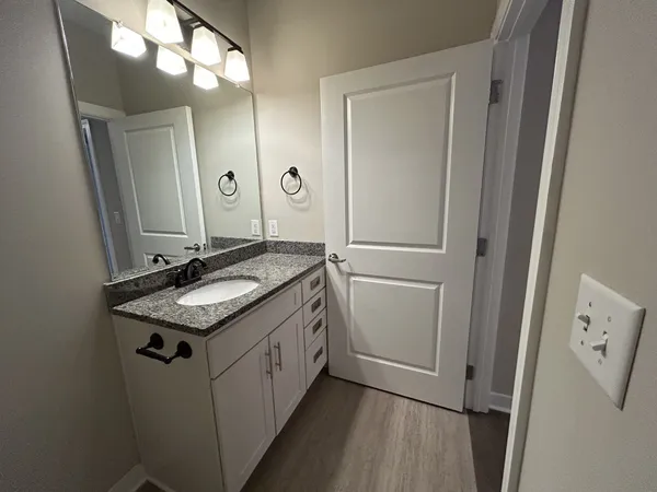 a bathroom with a granite countertop sink and a mirror