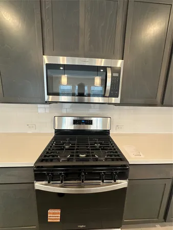 a stove top oven sitting inside of a kitchen