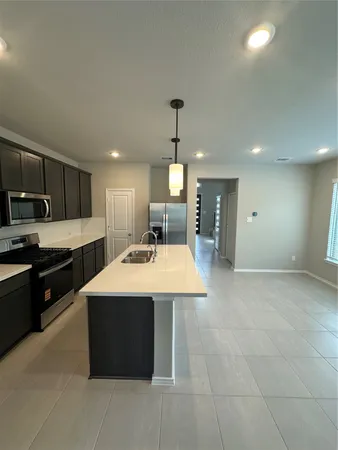 a large kitchen with kitchen island a sink stainless steel appliances and cabinets