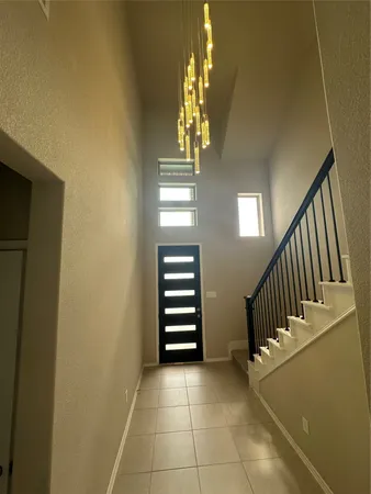 a view of staircase with railing and a chandelier