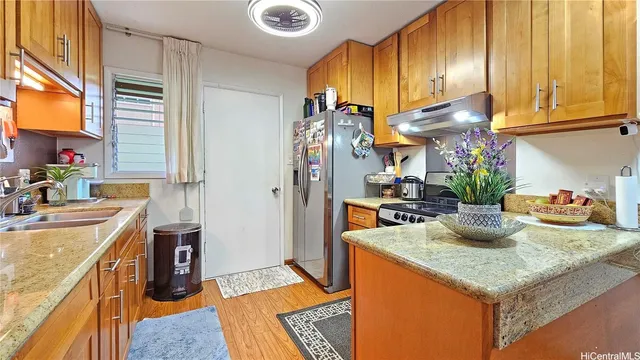 a kitchen with stainless steel appliances granite countertop sink stove and refrigerator