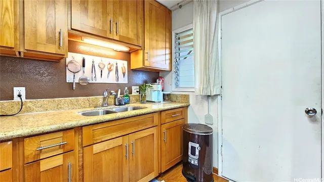 a kitchen with a sink cabinets and a window