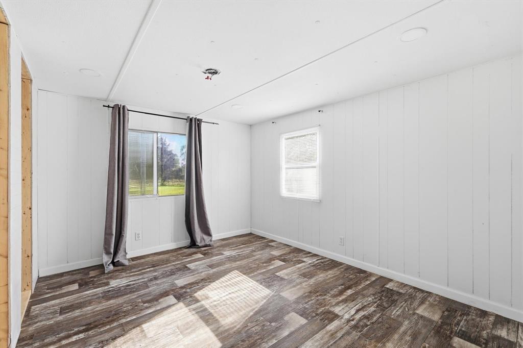 316 Summit Drive Springtown, TX 76082 - Photo 29 of 39 This bright room features durable wood-look flooring and white paneled walls, creating a clean and versatile aesthetic