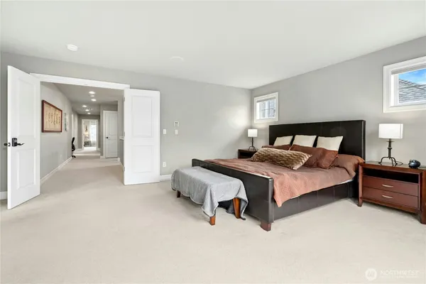 a large bathroom with a tub a double vanity sink a toilet a mirror and shower
